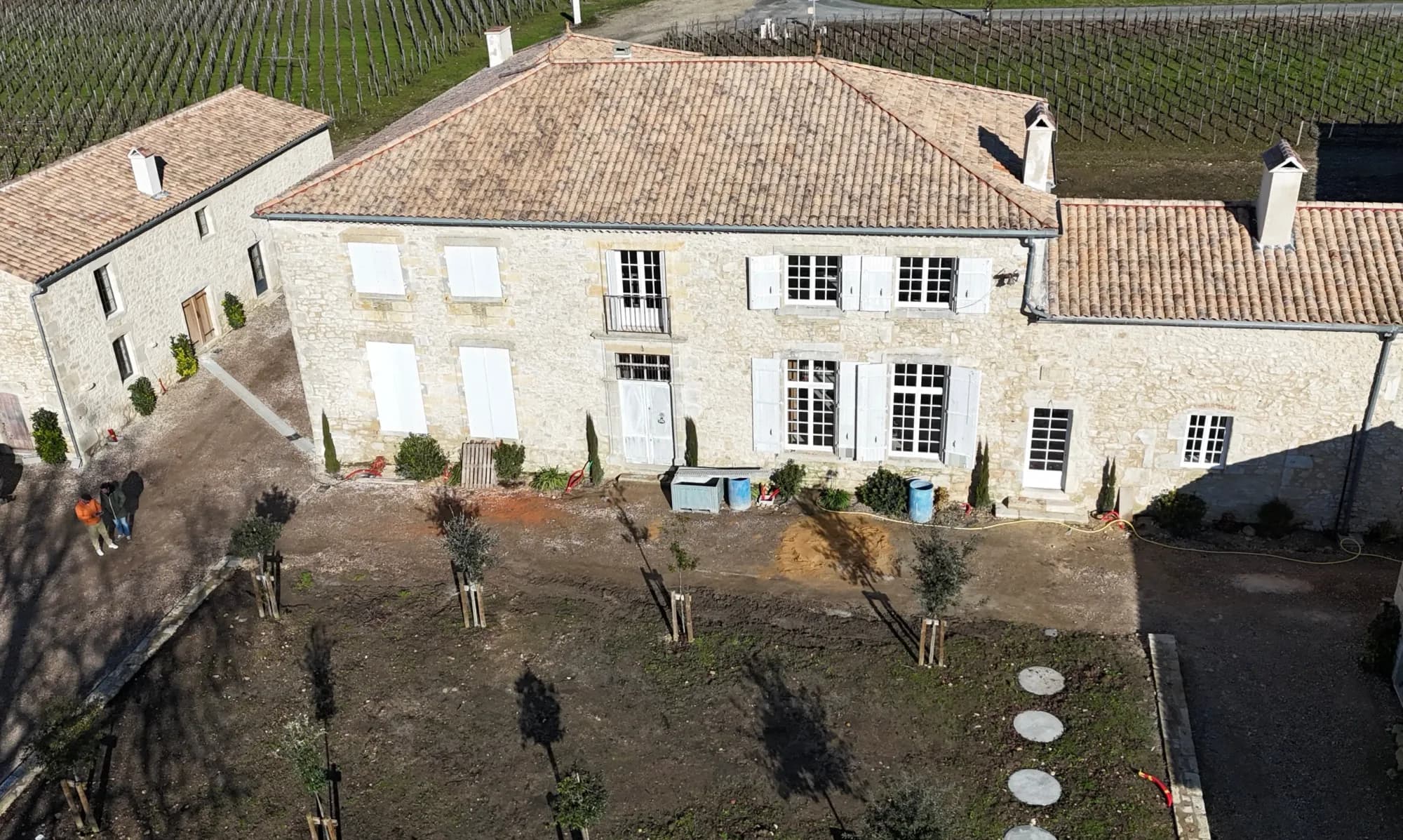Stone manor house surrounded by vineyards, aerial view