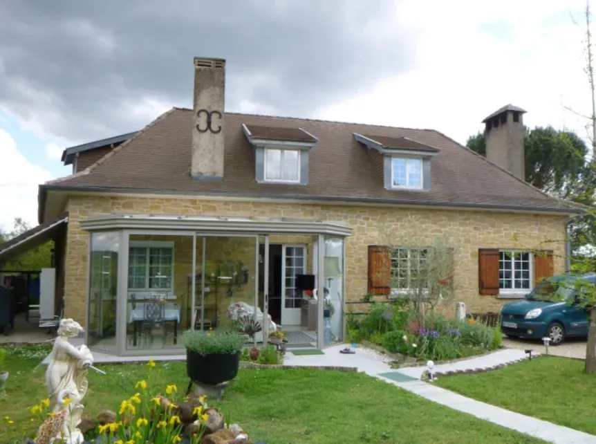 Stone house with a veranda and flower garden